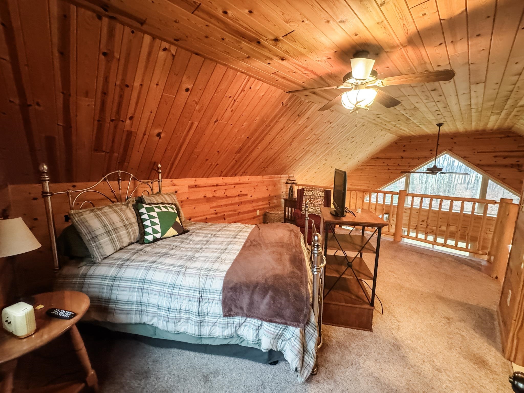 11466 Westerlund Loop Solon Springs, WI 54873 - Photo 23 of 55 Bedroom featuring wooden ceiling, vaulted ceiling, wood walls, carpet floors, and ceiling fan