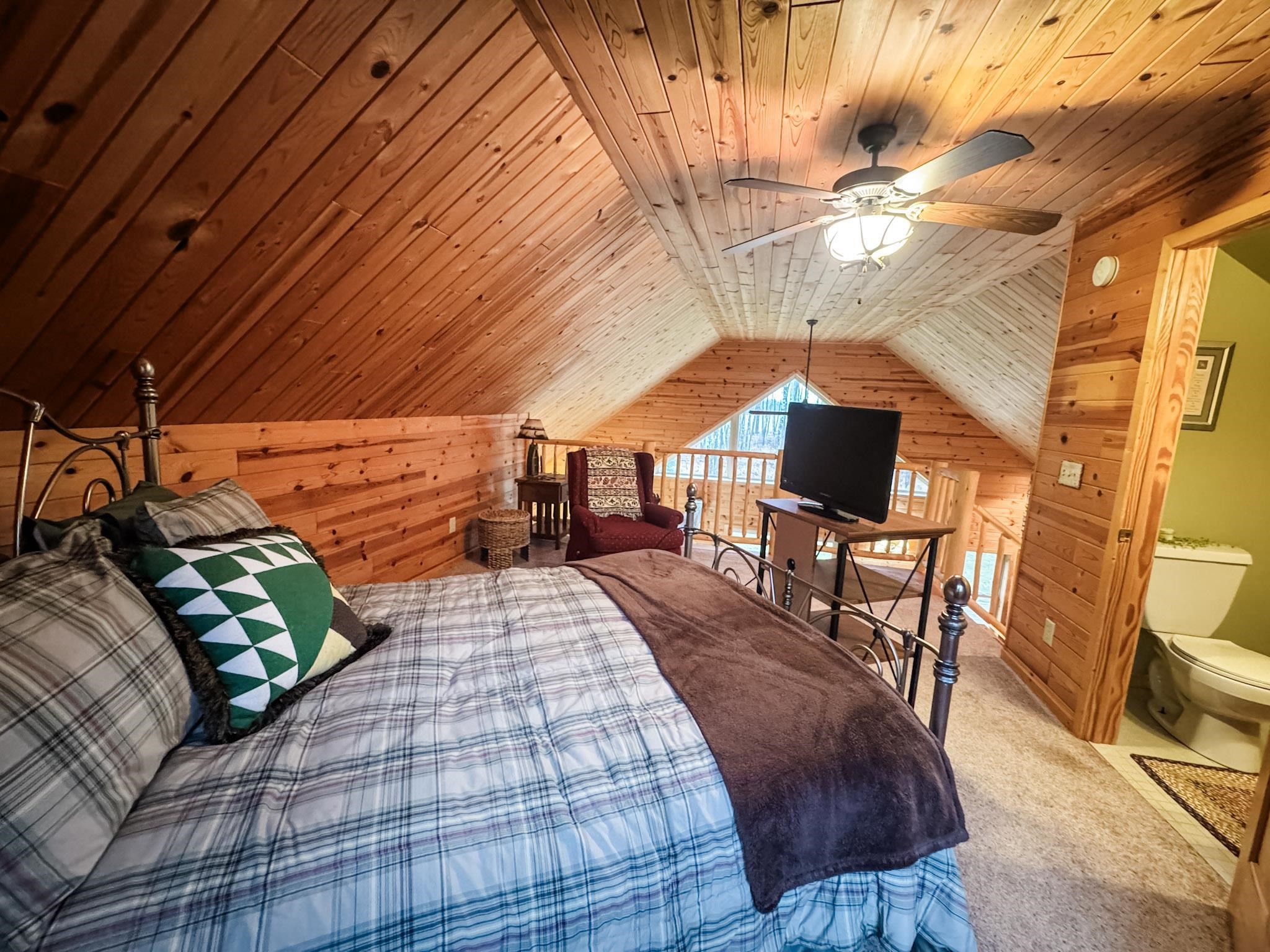 11466 Westerlund Loop Solon Springs, WI 54873 - Photo 25 of 55 Bedroom featuring wood walls, wooden ceiling, vaulted ceiling, carpet floors, and a ceiling fan