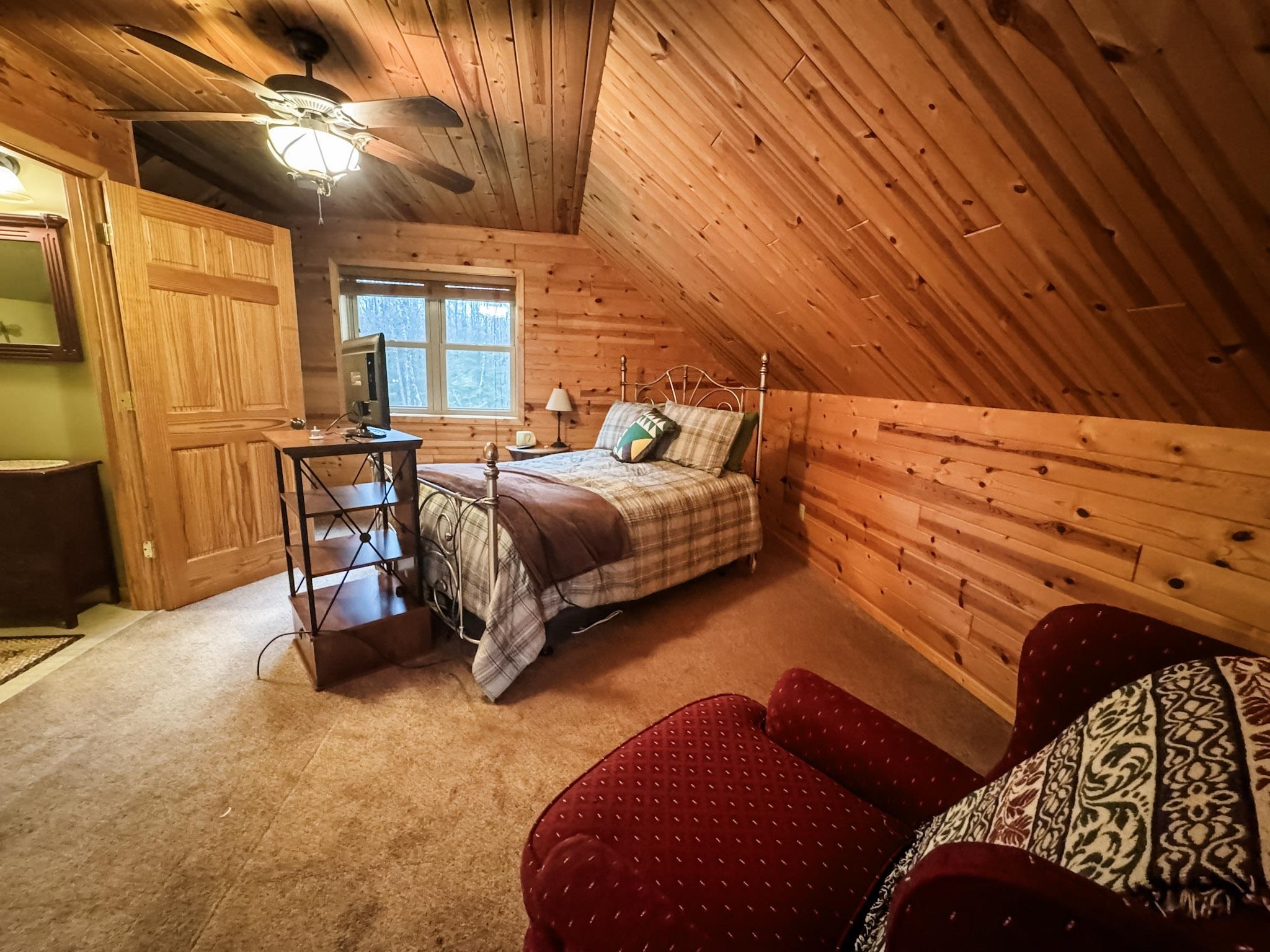 11466 Westerlund Loop Solon Springs, WI 54873 - Photo 26 of 55 Bedroom with wooden walls, lofted ceiling, wood ceiling, carpet flooring, and a ceiling fan