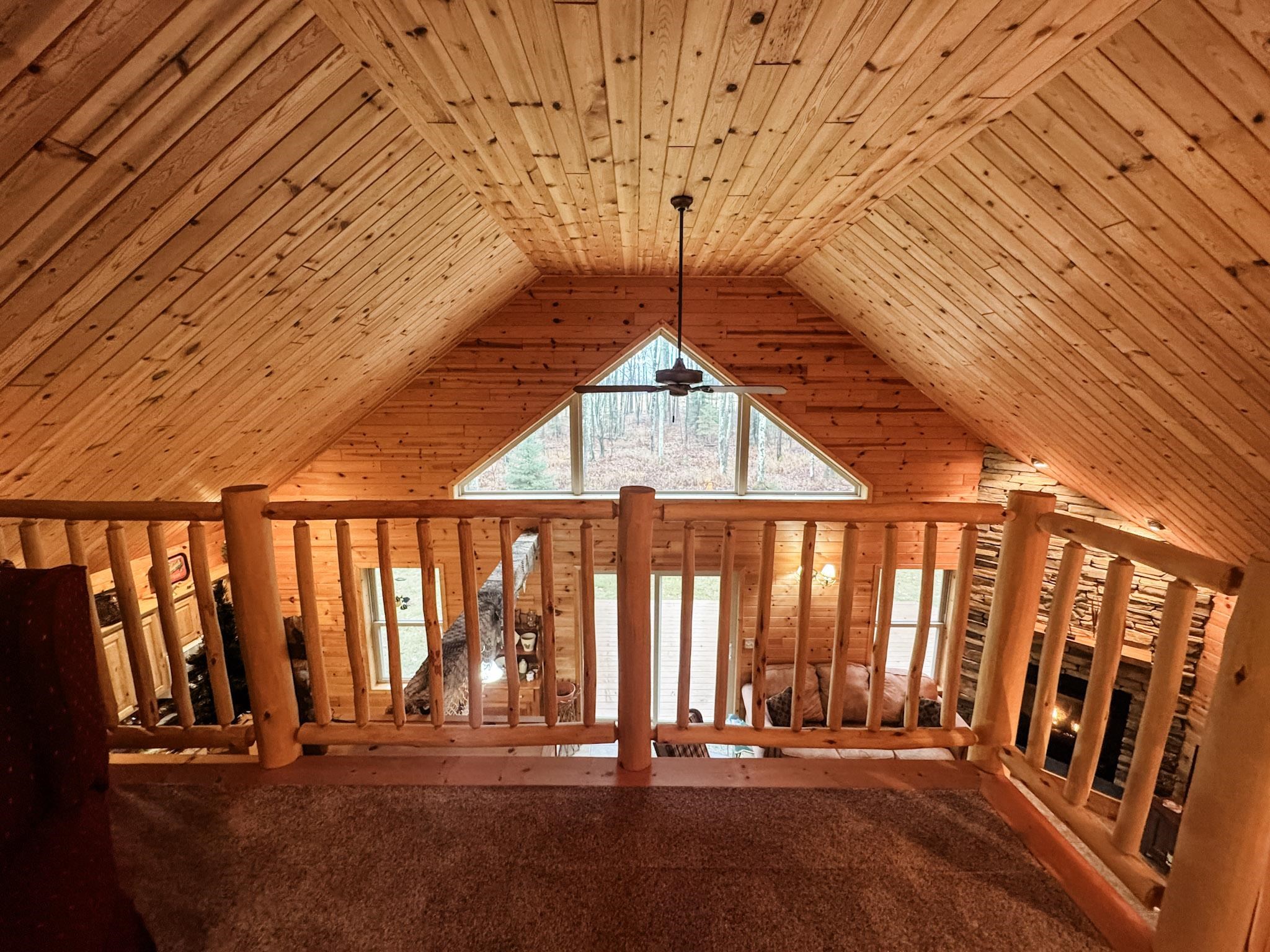 11466 Westerlund Loop Solon Springs, WI 54873 - Photo 29 of 55 Unfurnished living room with wood ceiling, a ceiling fan, wood walls, and high vaulted ceiling