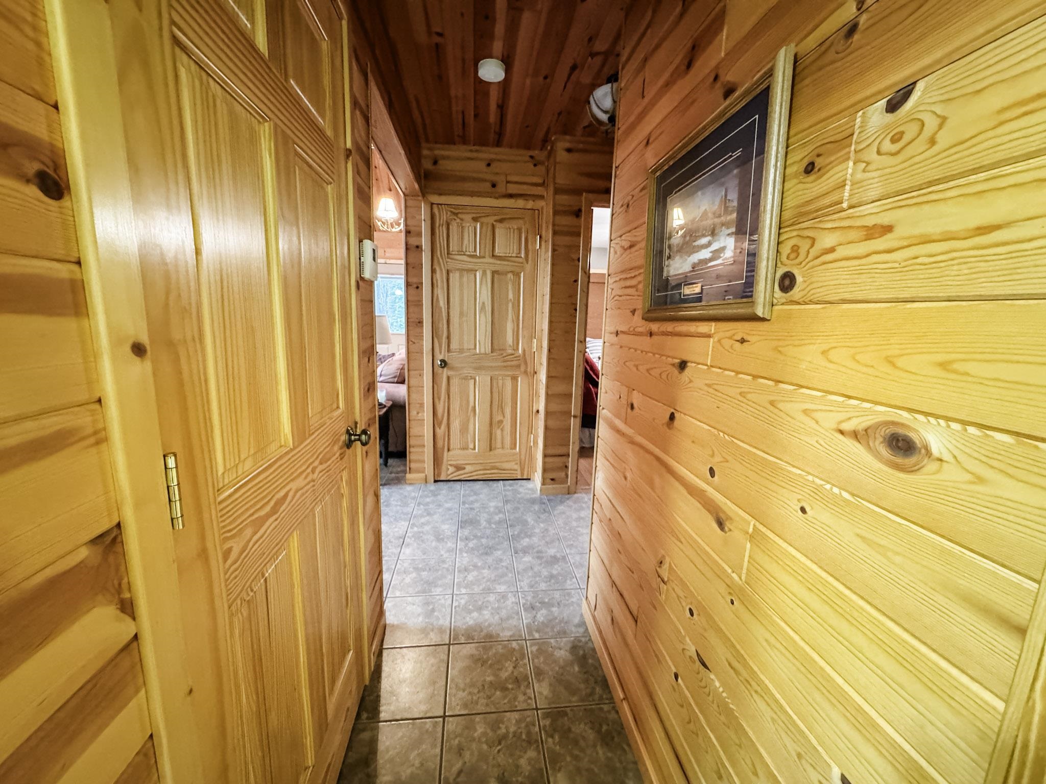 11466 Westerlund Loop Solon Springs, WI 54873 - Photo 32 of 55 Hall featuring wooden walls, wood ceiling, and dark tile patterned floors