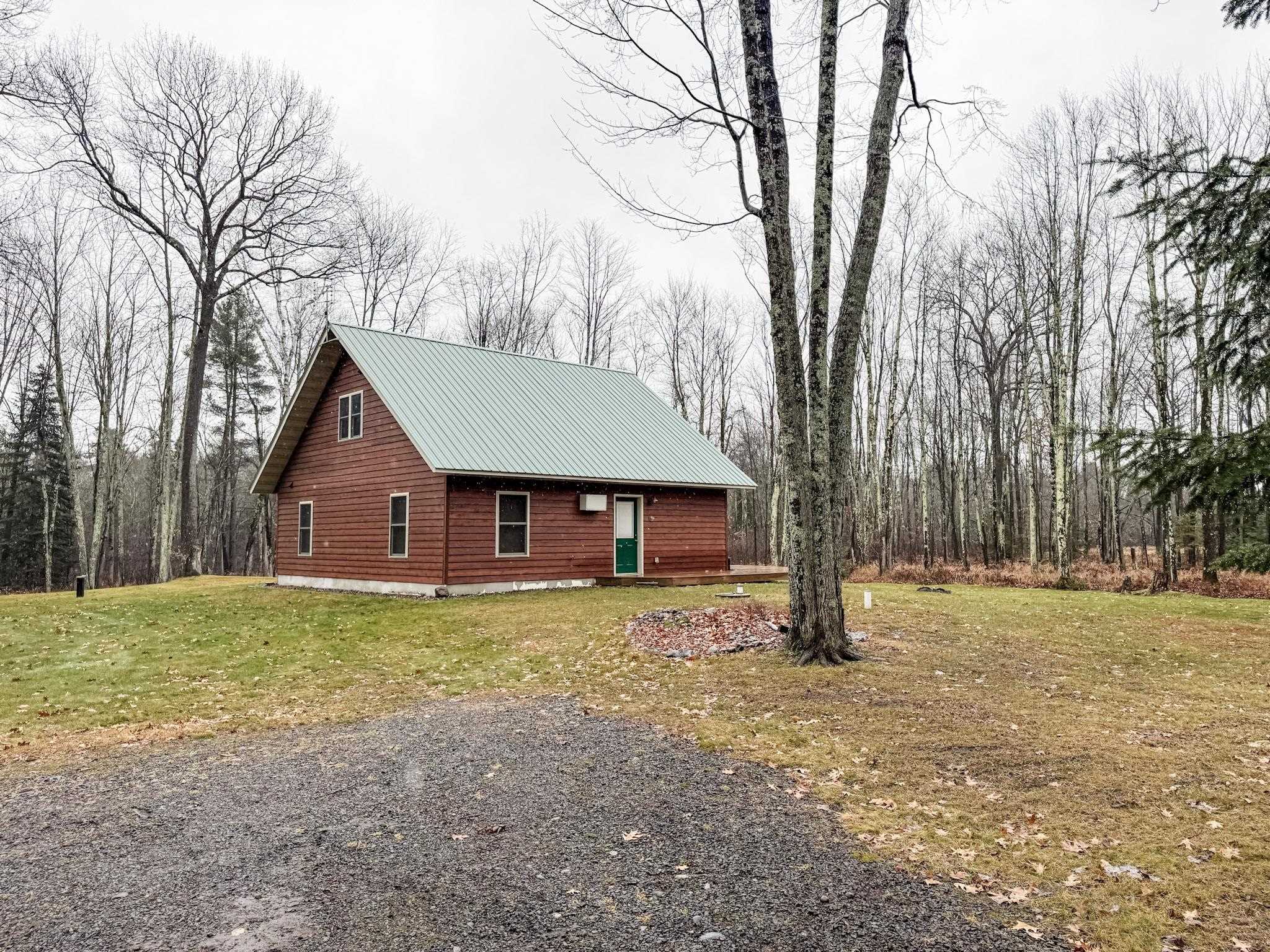 11466 Westerlund Loop Solon Springs, WI 54873 - Photo 53 of 55 View of home's exterior featuring a yard, a metal roof, and a forest view