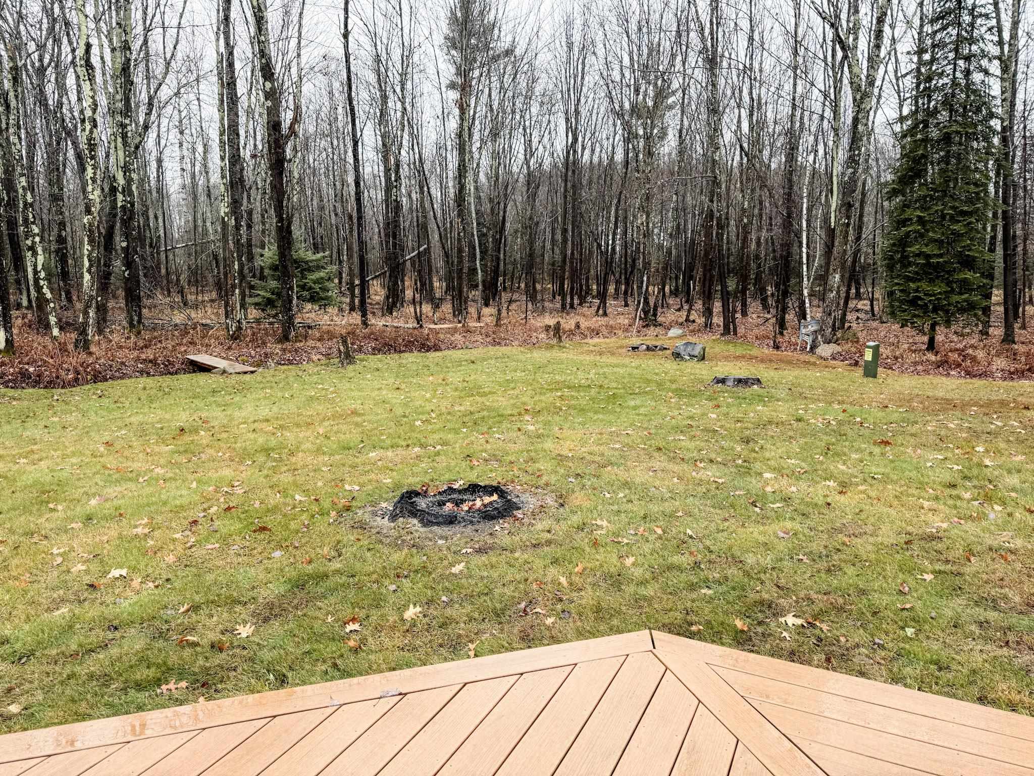 11466 Westerlund Loop Solon Springs, WI 54873 - Photo 9 of 55 View of green lawn featuring an outdoor fire pit