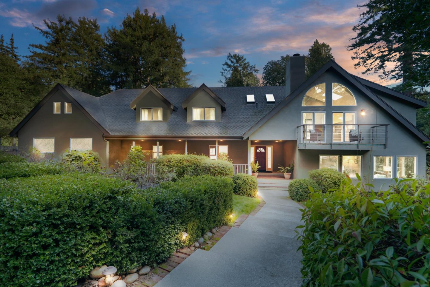 a front view of a house with a yard and trees