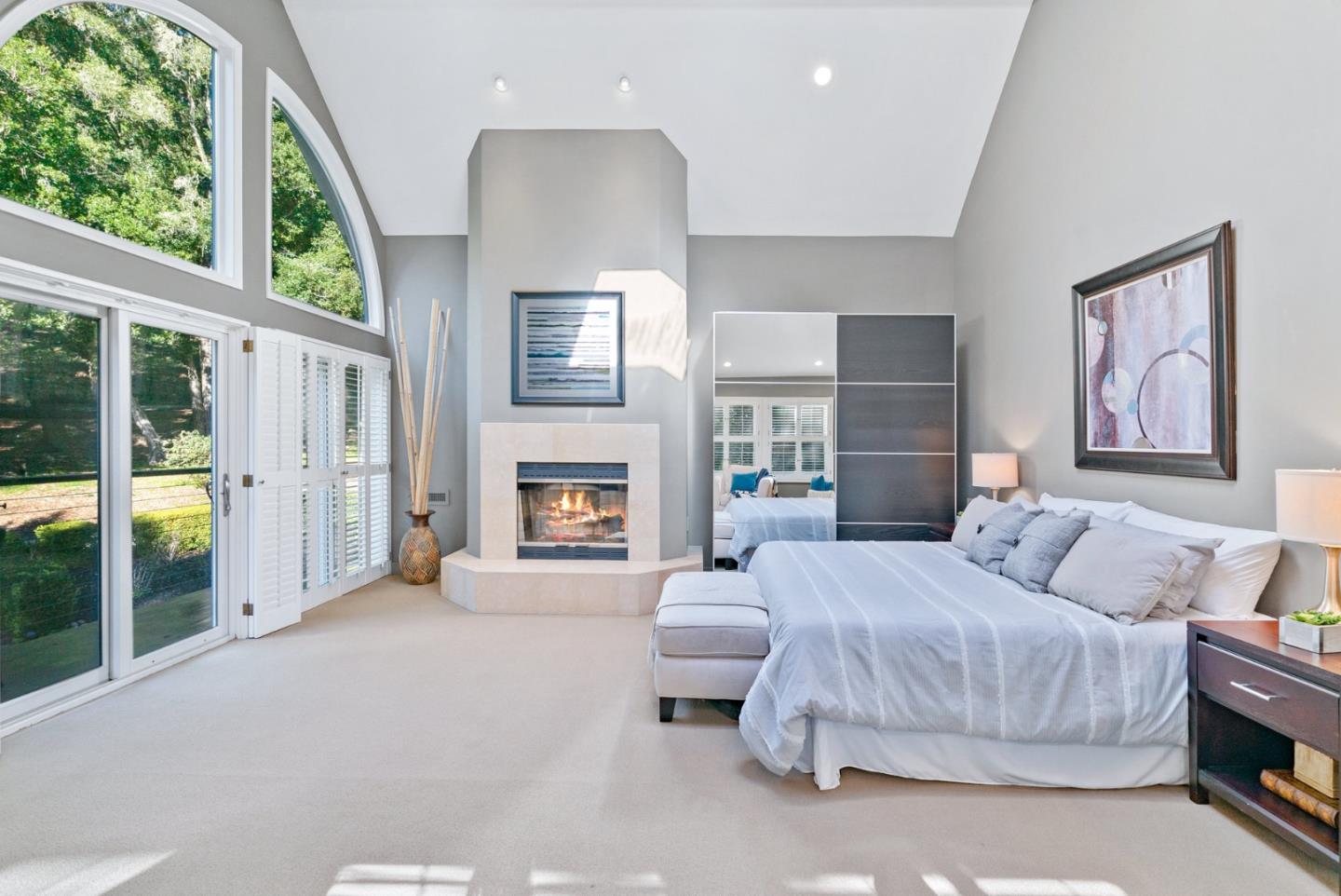 500 Bear Valley Road Aptos, CA 95003 - Photo 44 of 91 a spacious bedroom with a balcony a bed and a fireplace