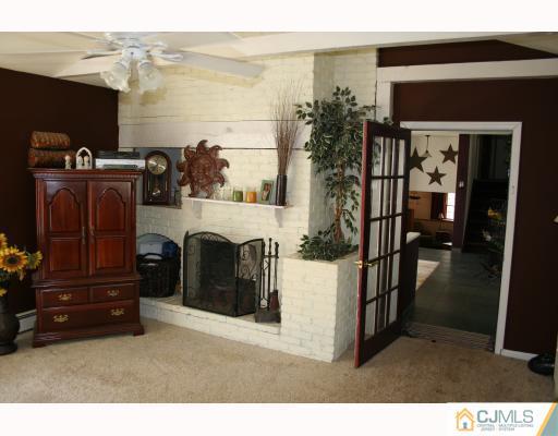 12 Baldwin Road Edison, NJ 08817 - Photo 2 of 10 a living room with furniture a flat screen tv and a fireplace