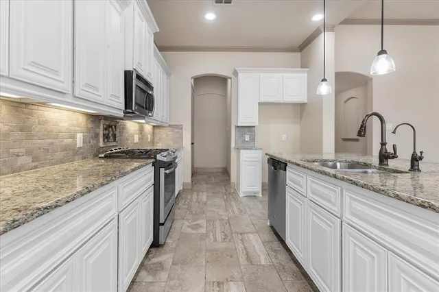 a kitchen with stainless steel appliances granite countertop a stove and a sink