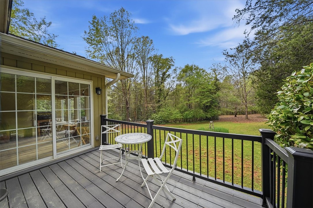 729 State Rd S-37-359 Seneca, SC 29672 - Photo 25 of 35 Enjoy tranquil views from this spacious deck, perfect for peaceful mornings or serene evenings.