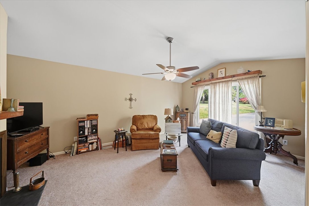 729 State Rd S-37-359 Seneca, SC 29672 - Photo 5 of 35 This living room features a vaulted ceiling and sliding glass doors, offering comfortable living and easy outdoor access.