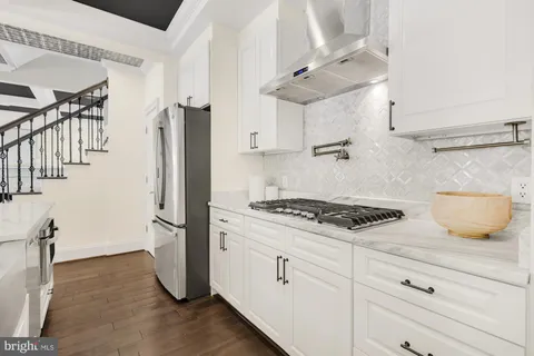 a kitchen with granite countertop a sink stove and cabinets