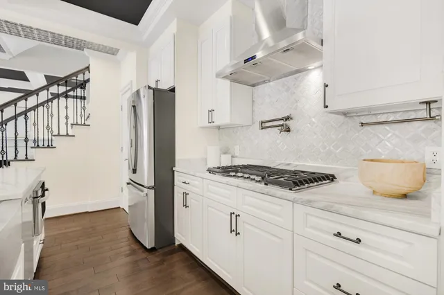 a kitchen with granite countertop a sink stove and cabinets