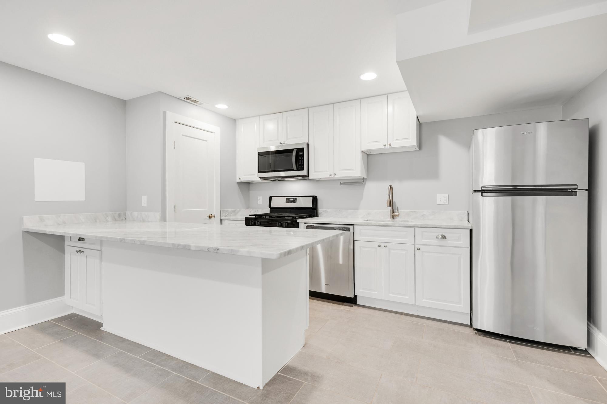 1202 Decatur Street Northwest Washington, DC 20011 - Photo 51 of 53 a kitchen with white cabinets and refrigerator
