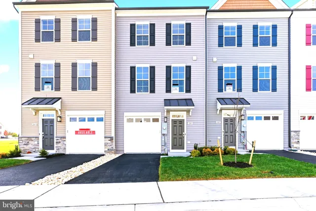 a front view of a building with a garden and pathway