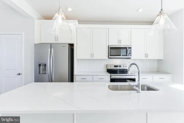 a kitchen with stainless steel appliances a stove a sink a microwave and cabinets