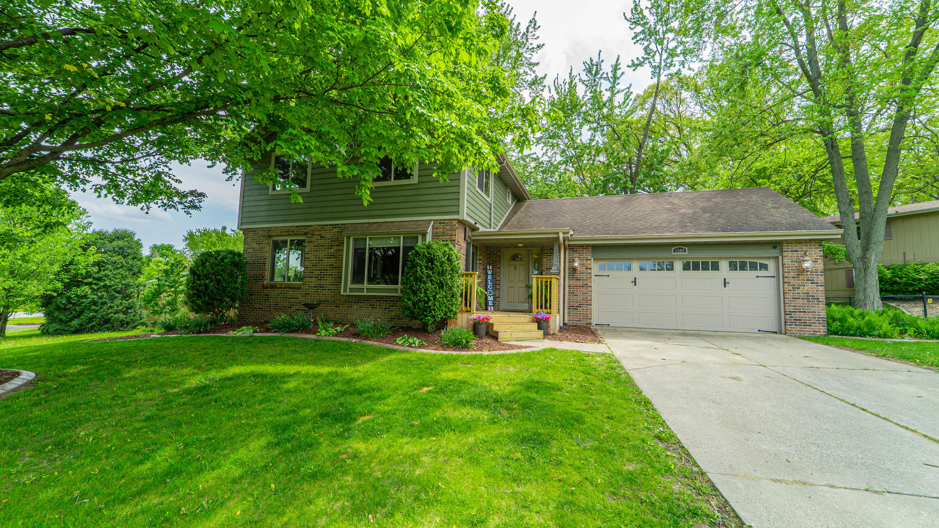 a front view of a house with a yard and trees