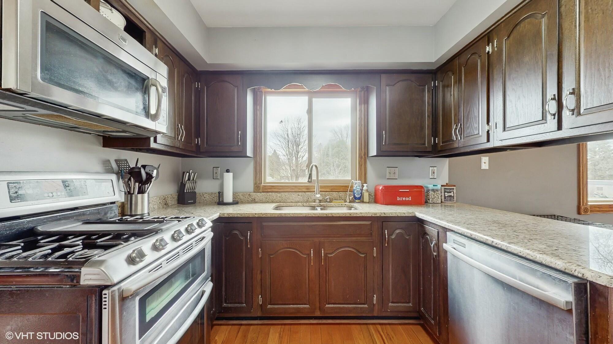 1980 Greenvalley Drive Crown Point, IN 46307 - Photo 13 of 45 a kitchen with stainless steel appliances granite countertop a sink stove top oven and cabinets