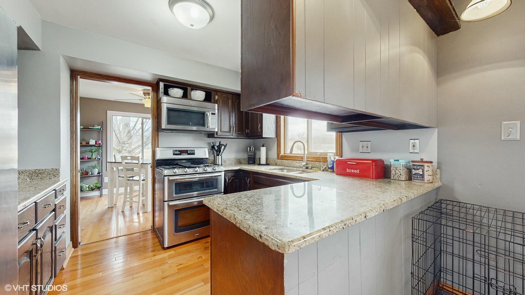 1980 Greenvalley Drive Crown Point, IN 46307 - Photo 14 of 45 a kitchen with stainless steel appliances granite countertop a sink a stove and a refrigerator