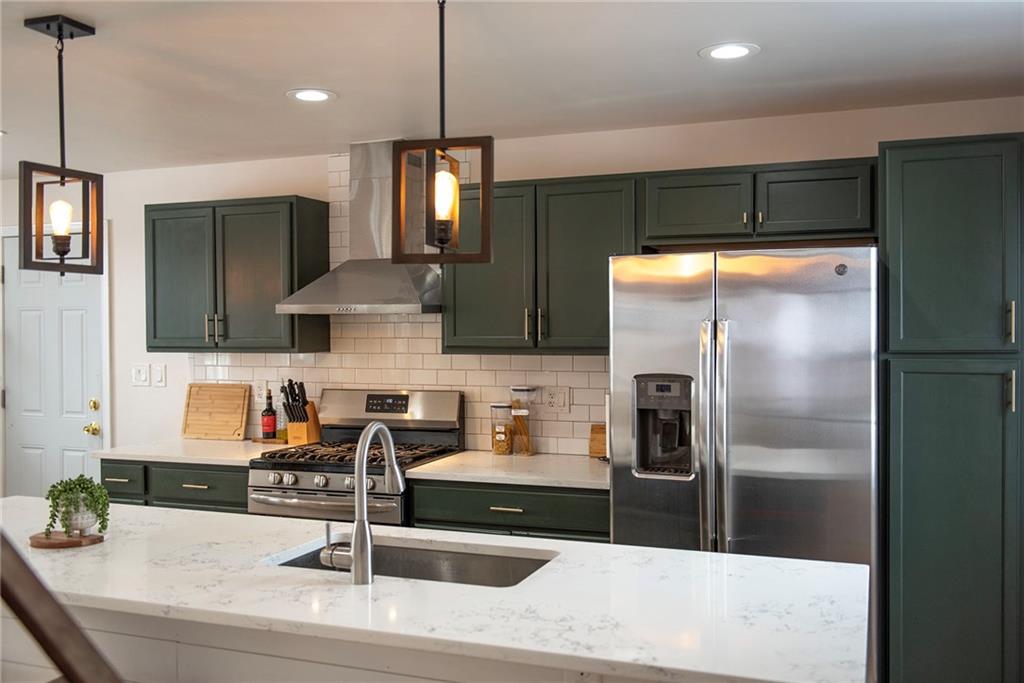 1315 Bower Hill Road Pittsburgh, PA 15243 - Photo 21 of 43 a kitchen with stainless steel appliances kitchen island granite countertop a refrigerator and a sink
