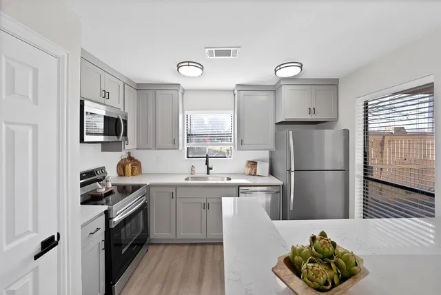a kitchen with a sink a refrigerator and cabinets