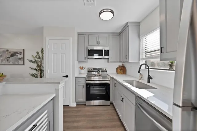 a kitchen with stainless steel appliances granite countertop a sink and a stove top oven