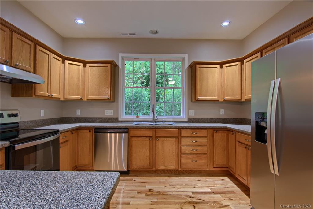 2322 Locust Grove Road Hendersonville, NC 28792 - Photo 11 of 40 a kitchen with stainless steel appliances granite countertop a refrigerator sink and cabinets