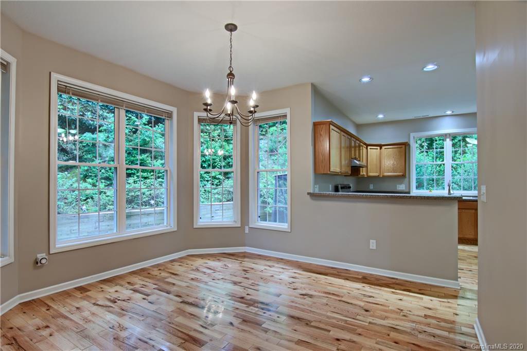 2322 Locust Grove Road Hendersonville, NC 28792 - Photo 14 of 40 a view of empty room with wooden floor and chandelier