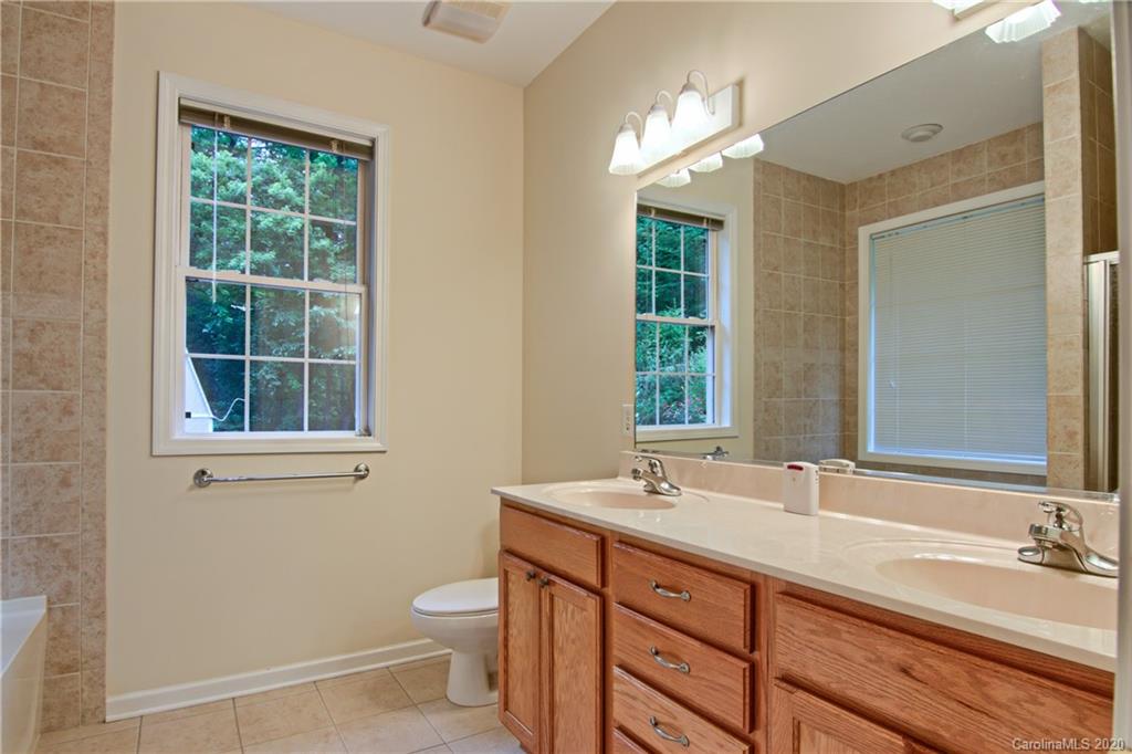 2322 Locust Grove Road Hendersonville, NC 28792 - Photo 19 of 40 a bathroom with a double vanity sink toilet and a mirror