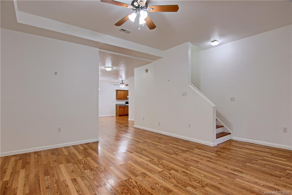 2322 Locust Grove Road Hendersonville, NC 28792 - Photo 28 of 40 a view of an empty room with wooden floor and a ceiling fan