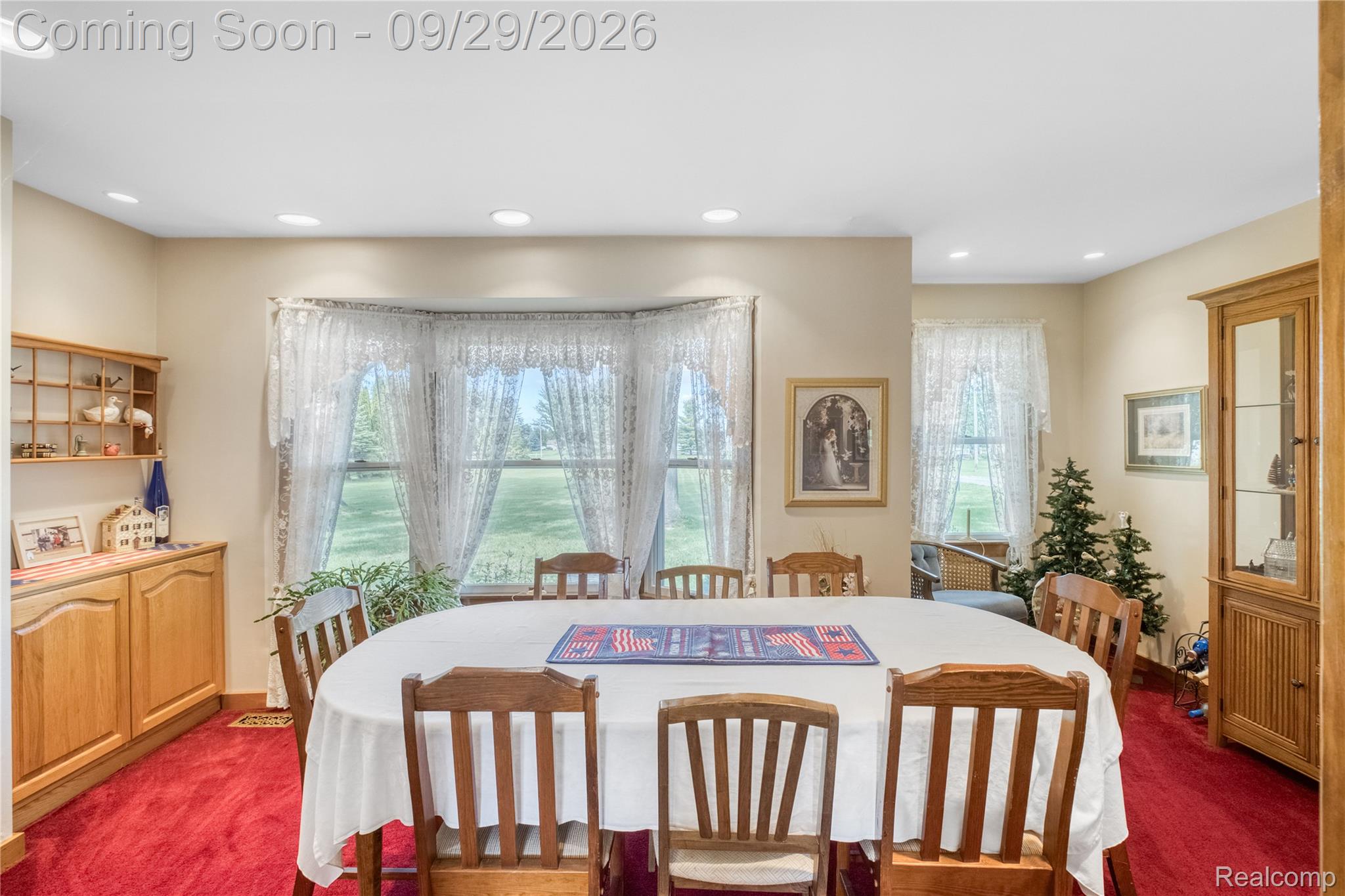 6411 Farrand Road Clio, MI 48420 - Photo 16 of 33 Recessed lighting, bay window, light-toned walls, hardwood cabinetry, and red carpeting