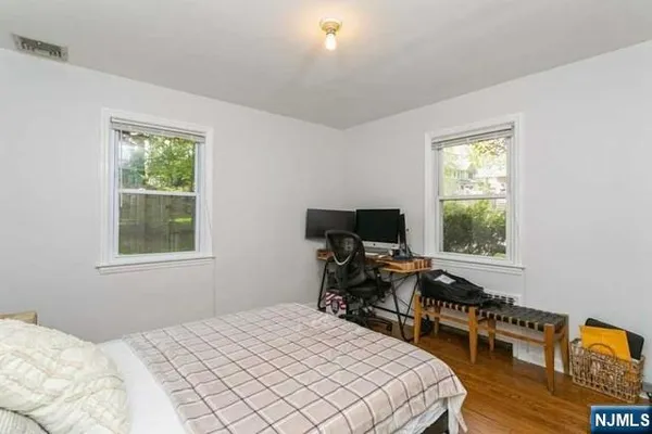 a bedroom that has a bed and a desk in it with window