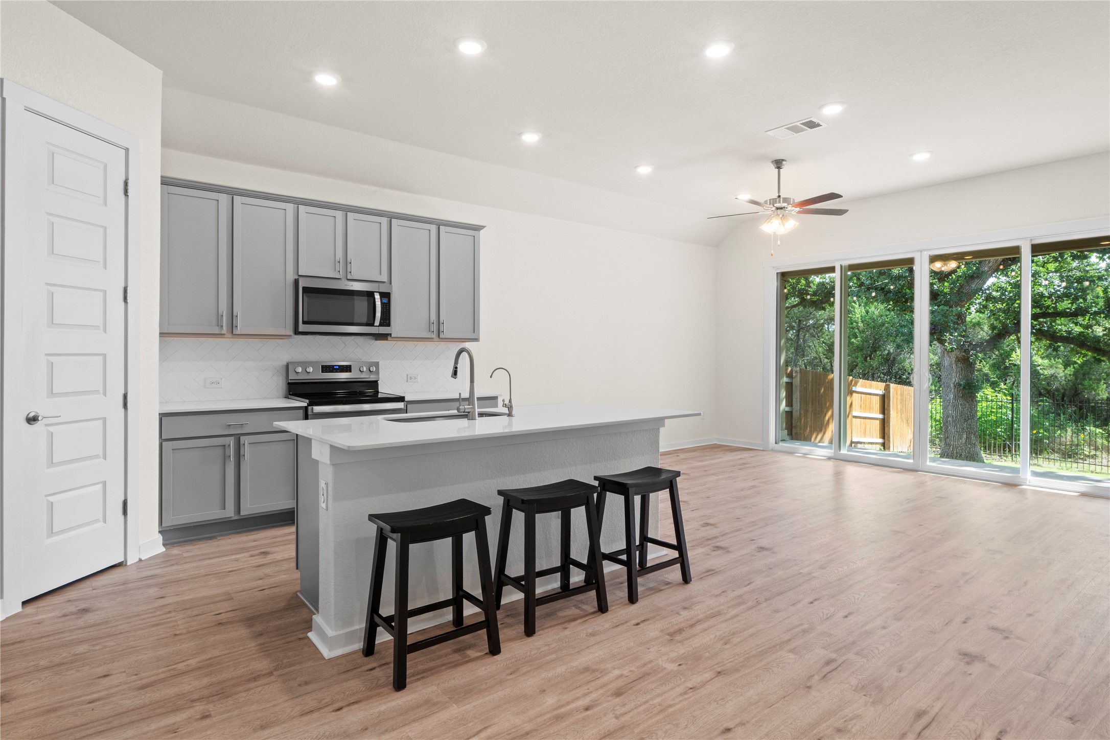 341 Peace Pipe Way Georgetown, TX 78628 - Photo 6 of 28 Painted cabinets, hardware, stainless steel appliances and quartz counters give this kitchen a modern look.