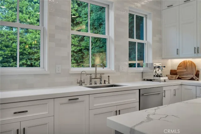 a spacious bedroom with a bed a dresser and painting on the wall