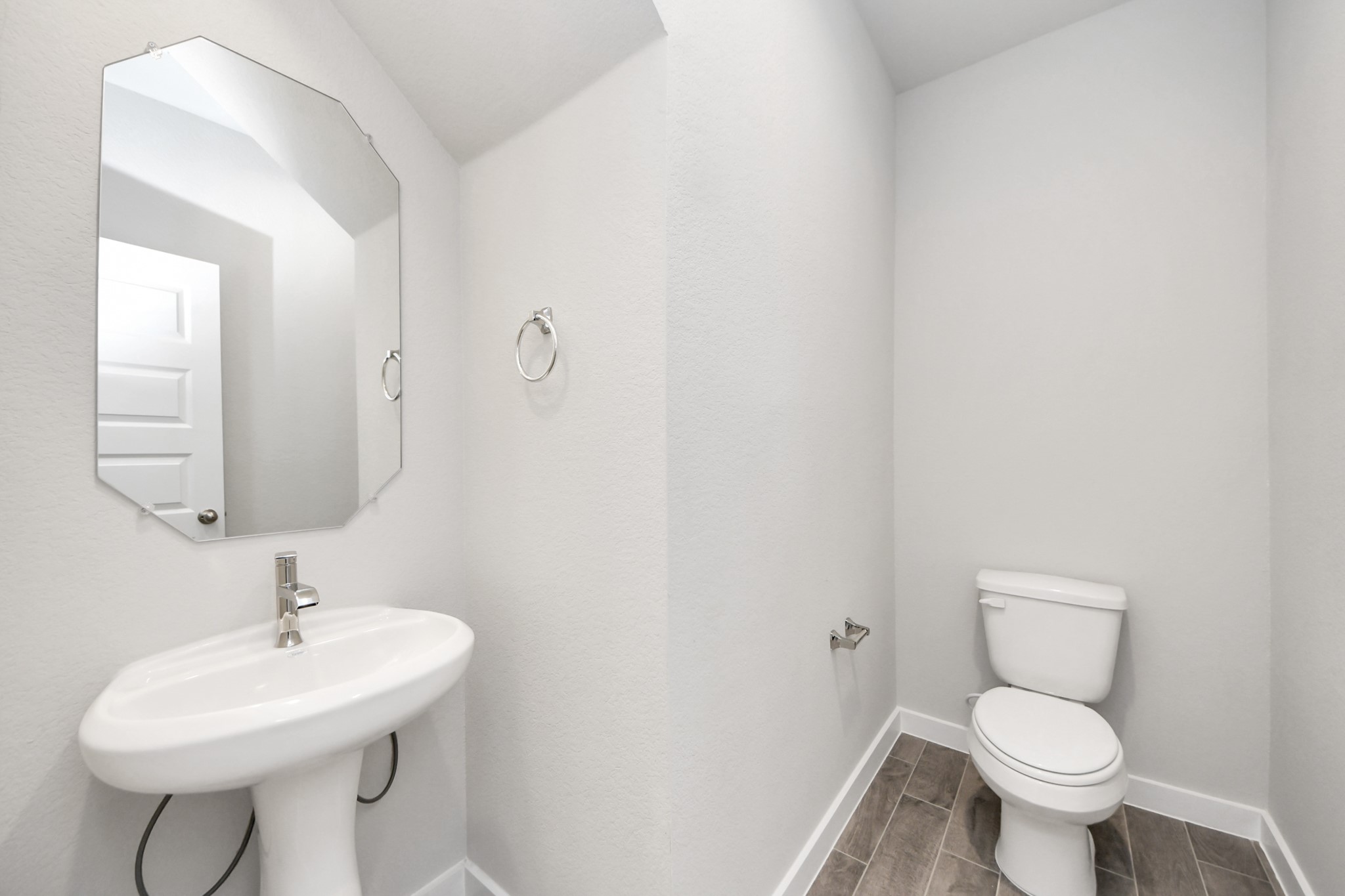 24502 Broad Park Spring, TX 77373 - Photo 11 of 47 This half bathroom features a stylish pedestal sink, modern hardware, and bright recessed lighting, creating a sleek and inviting space.