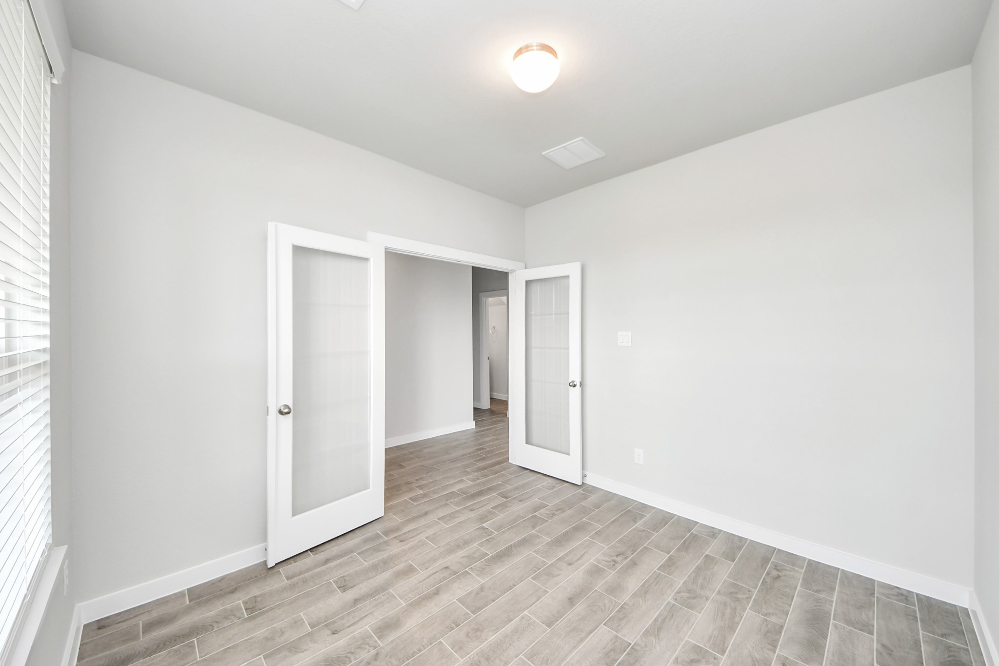 24502 Broad Park Spring, TX 77373 - Photo 9 of 47 Step into the inviting home office, where elegant tile flooring adds a touch of freshness and comfort to the workspace. Natural light pours through the window, creating an inspiring environment for productivity and focus.