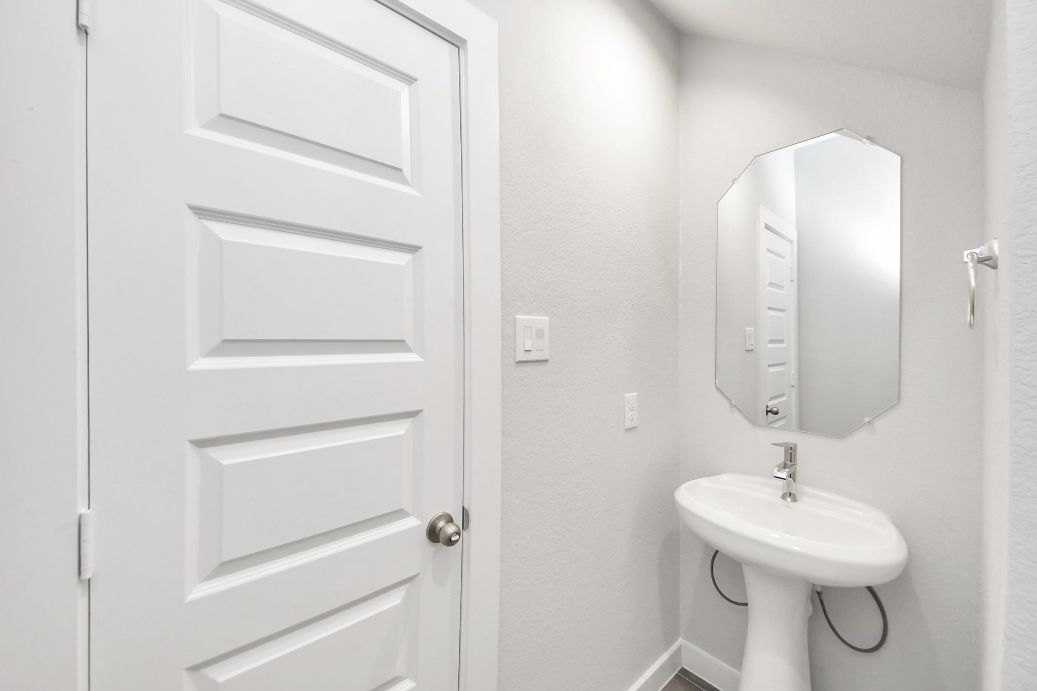 24502 Broad Park Spring, TX 77373 - Photo 10 of 47 Step into this bright and airy half bath, where a sleek pedestal sink and modern hardware elevate the space with contemporary charm.