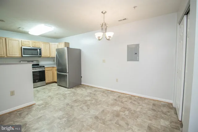a view of kitchen with refrigerator stove microwave and cabinets