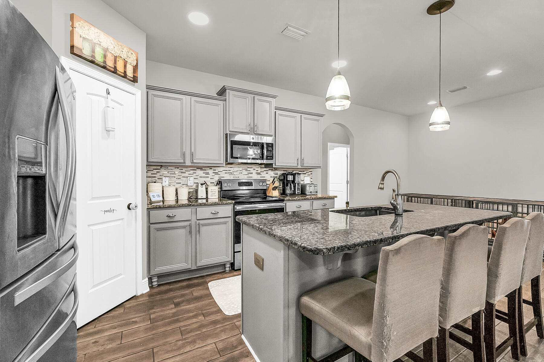 682 Teal Street Crestview, FL 32539 - Photo 7 of 34 a kitchen with stainless steel appliances granite countertop a sink a stove a refrigerator cabinets and chairs