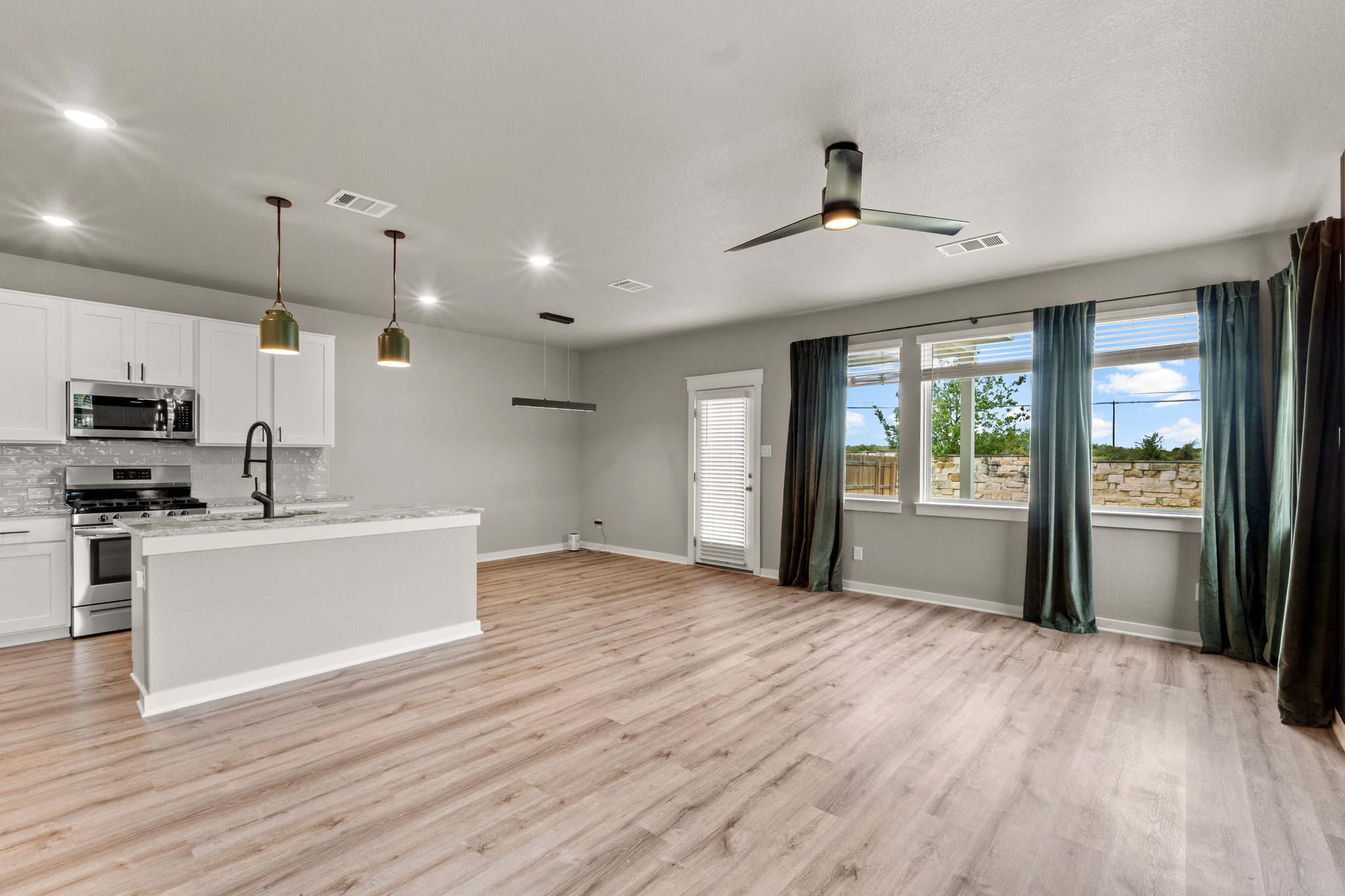 2251 Rocoso Trail Leander, TX 78641 - Photo 4 of 34 Smooth wood floors flow seamlessly through this open-concept kitchen and dining area.