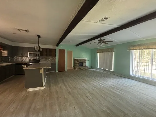 a view of an empty room with a fireplace and a window