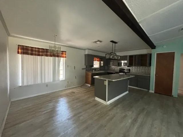 a kitchen with stainless steel appliances kitchen island sink stove and cabinets
