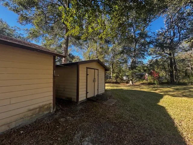 a backyard of a house with wooden floor barbeque oven and outdoor seating