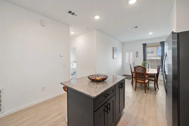 a kitchen with granite countertop kitchen island stainless steel appliances a table and chairs