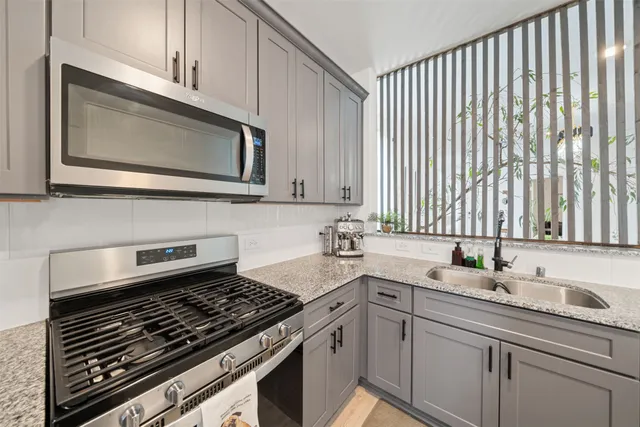 a kitchen with stainless steel appliances a sink stove and cabinets