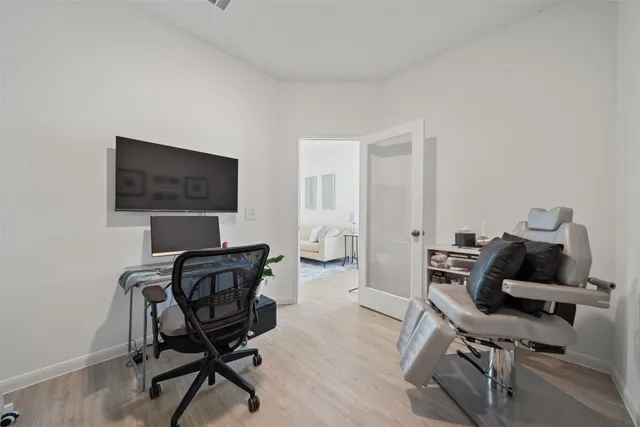 a view of a workspace with furniture and a window