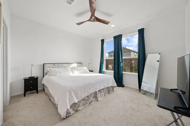 a bedroom with a bed tv and a large mirror
