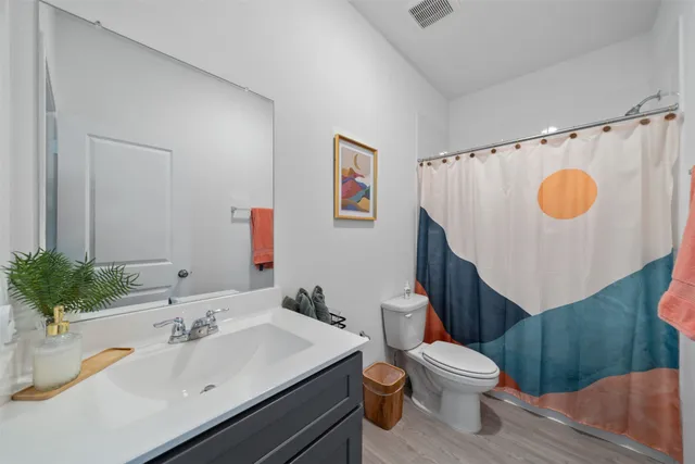 a bathroom with a sink mirror vanity and toilet