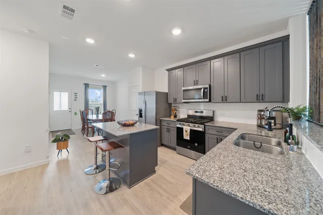 a kitchen with a sink a counter top space appliances and cabinets