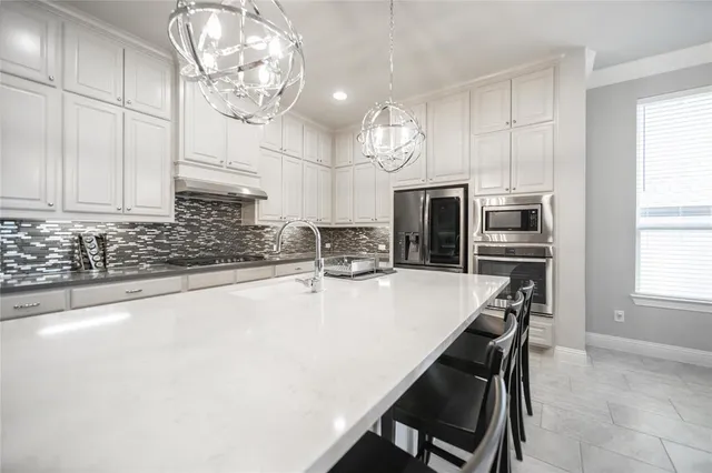a kitchen with kitchen island a large counter top space appliances and cabinets