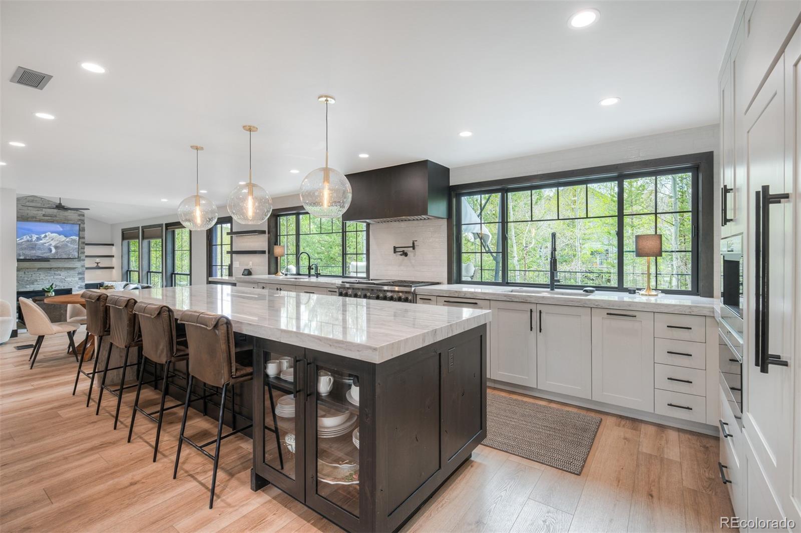 306 Golden Eagle Road Silverthorne, CO 80498 - Photo 6 of 43 a kitchen with stainless steel appliances granite countertop a stove a sink dishwasher and a dining table with wooden floor