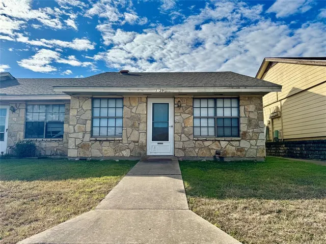 a front view of a house with a garden and yard